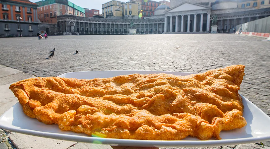 Жареная пицца на фоне Пьяцца-дель-Плебисцито, главной площади Неаполя