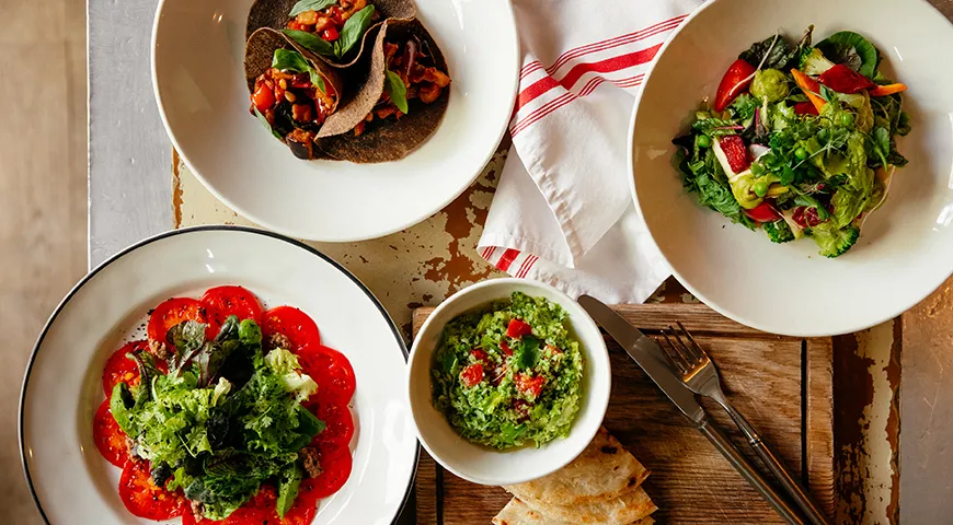 Зеленый салат с двумя видами помидоров, сицилийская капоната, гуакамоле из брокколи и авокадо с помидорами и веганской лепешкой роти и ризотто примавера