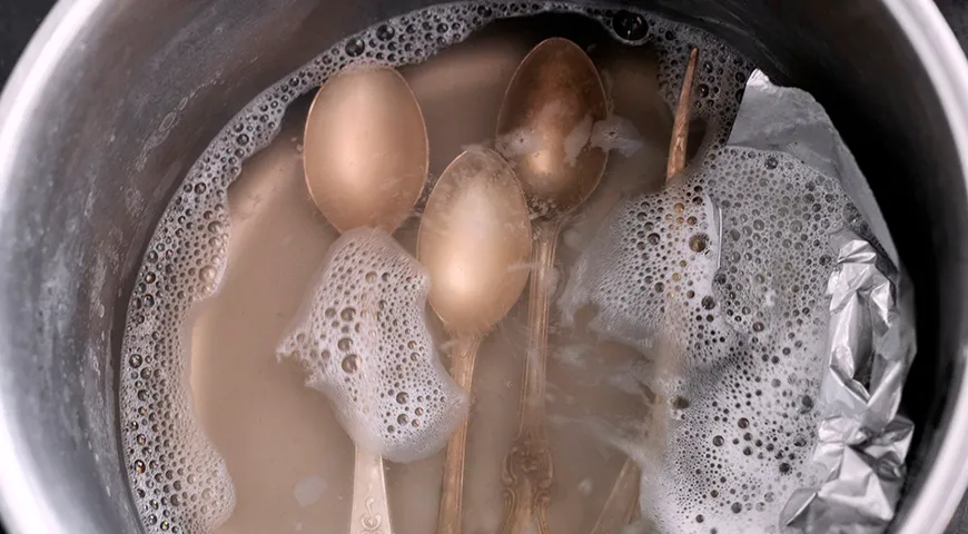 Вернуть блеск столовым приборам можно, замочив их в кипятке с содой и уксусом на 10 минут 