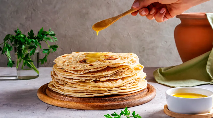 Чтобы придать лепешке роти невероятную мягкость и сливочный аромат, смажьте ее топленым маслом