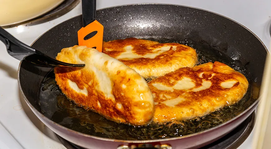 Пирожки жарят с каждой стороны по 2–4 минуты, а затем дожаривают, прикрыв крышкой