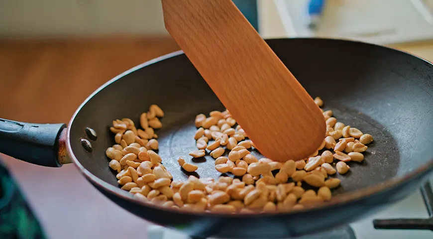 Чтобы орехи на сковороде прожарились равномерно, постоянно перемешивайте их