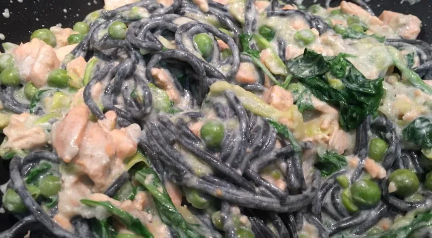 Черные спагетти с красной рыбой, зелёным горошком и голубым сыром