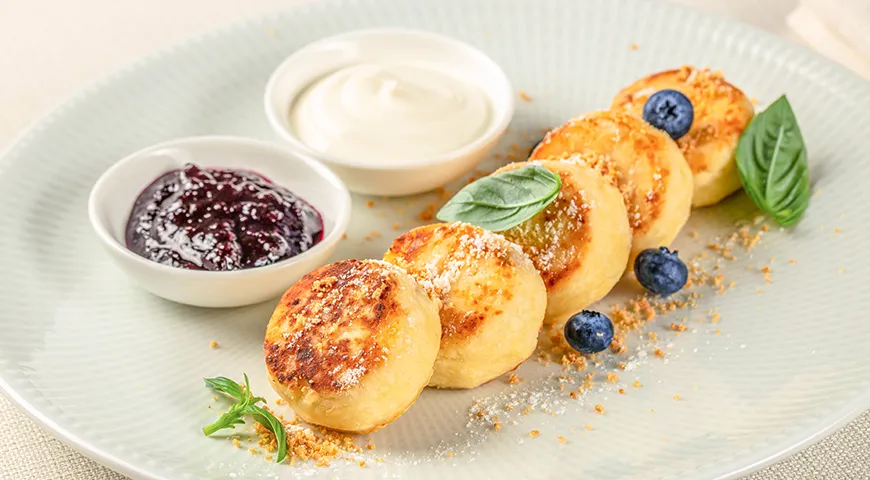 Сырники можно подать с традиционными русскими добавками: густой сметаной и домашним вареньем