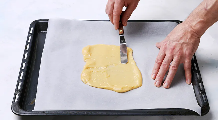 Разровнять тесто по бумаге нужно довольно быстро. И смело тяните его к углам!