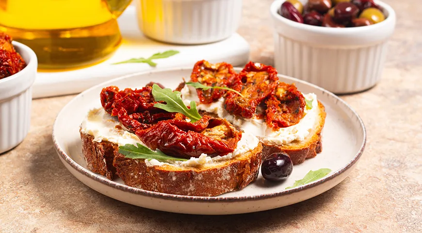 Сэндвич на сером хлебе с творожным сыром и вялеными томатами