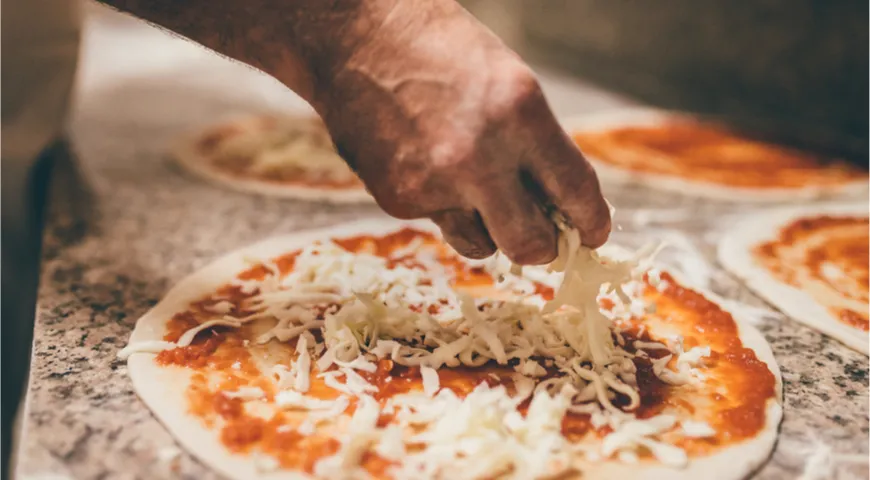 Посыпайте пиццу хорошо плавящимся в меру твердым сыром, предварительно натертым на терке