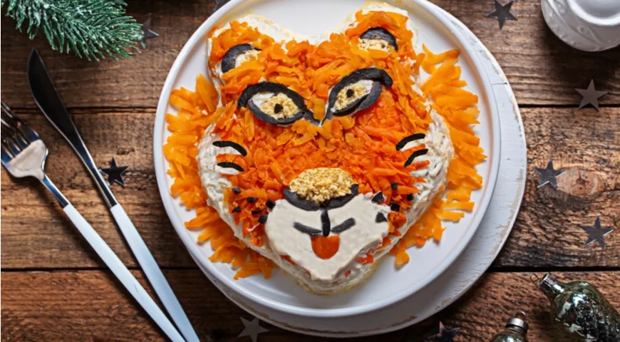 Тигр, символ Нового 2022 года на тарелке с рыбным салатом