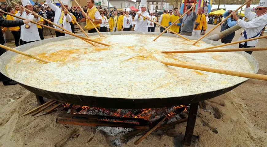 Члены Братства Гигантских Омлетов Бессьера готовят гигантский омлет на главной площади родного города
