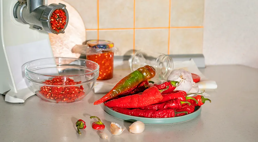 Классическую аджику готовят без добавления помидоров, в ее состав входит только острый перец, чеснок, зелень, соль и специи