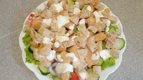 Салат с овощами, обжаренной куриной грудкой и сухариками.