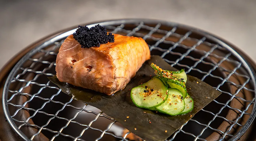 Лосось на гриле сперва готовят до хрустящей корочки со стороны кожи, затем обжигают с других сторон. Так появляется зажаристый вкус и аромат живого огня