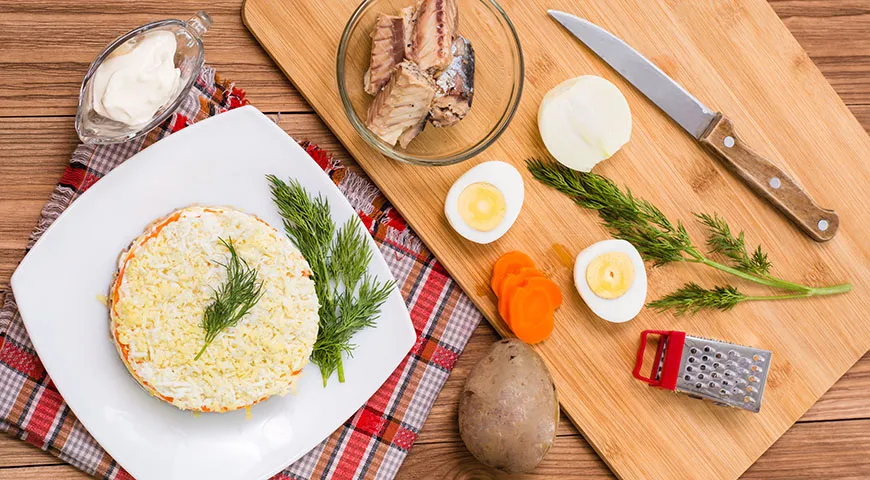 Классический рецепт салата «Мимоза» содержит консервированную рыбу, вареные яйца, лук, картошку, сыр, сливочное масло и майонез