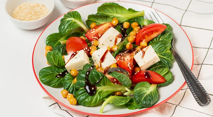 Свежий салат пак-чой с помидорами, нутом и сыром фета, заправленный соусом и семенами кунжута