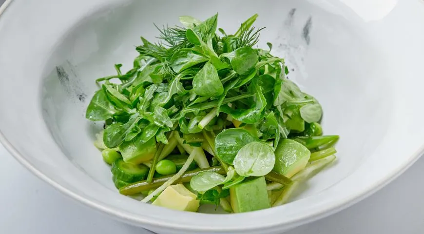 Зеленые листья салата с авокадо и спаржей