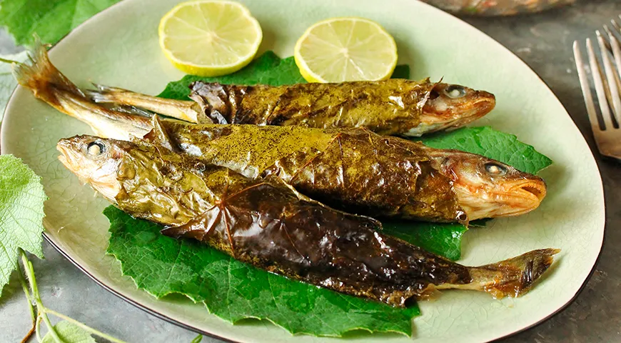Мелкая навага, запеченная в виноградных листьях