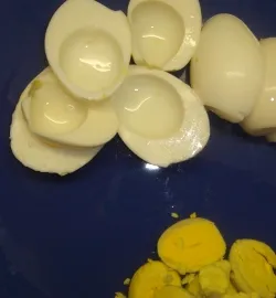 Шаг 2  Разрезать аккуратно ножом яйца пополам по длине.  Аккуратно вытащить желтки из белков яиц.