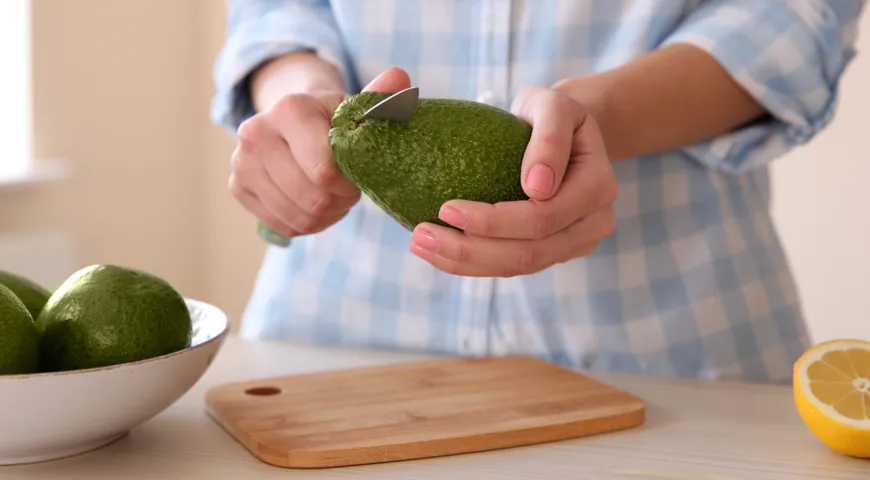 Готовим авокадо для еды, разрезаем плод; будьте аккуратны с ножом!