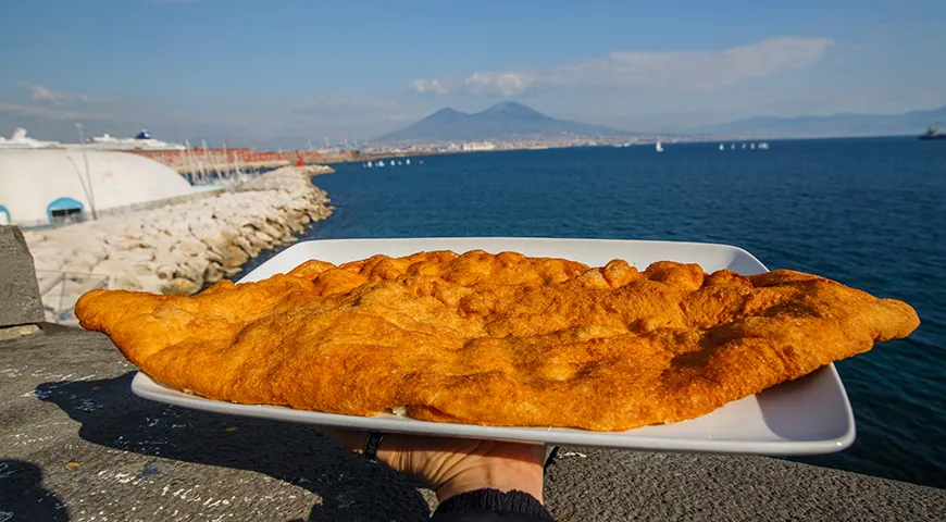 Жареная пицца из Неаполя на фоне вулкана Везувий