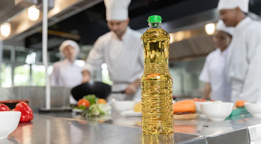 Рафинированное пальмовое масло в бутылке на кухонном столе