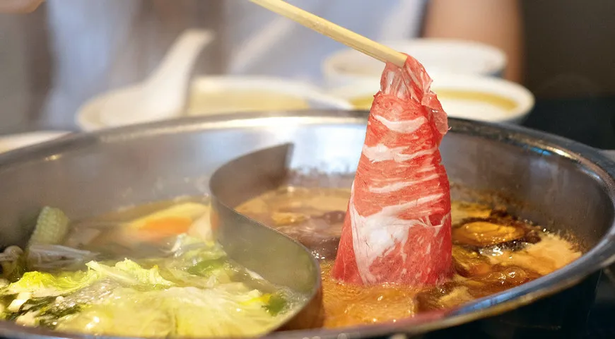 Блюдо набэмоно-сукияки представляет собой кипящий бульон с лапшой, пекинской капустой и грибами, в который нужно опускать прозрачные ломтики говядины.