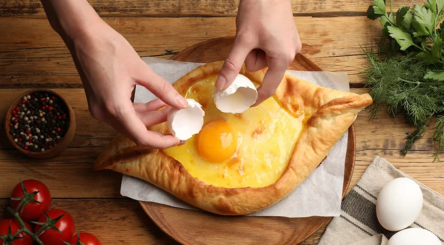 Перед самой подачей хачапури по-аджарски на горячий сыр выкладывают сырой желток