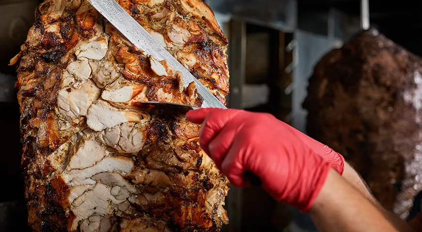 Вертел медленно вращается, и внешний слой мяса постепенно становится зажаренным и хрустящим, а внутренняя часть остается сочной