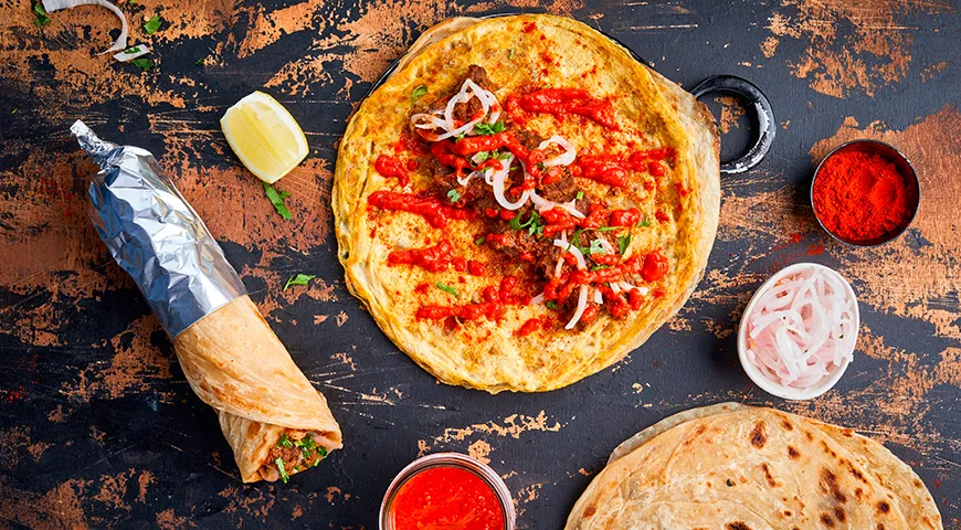 Лепешка роти идеально подходит для того, чтобы завернуть в нее пряное мясо, свежие овощи и полить любимым соусом