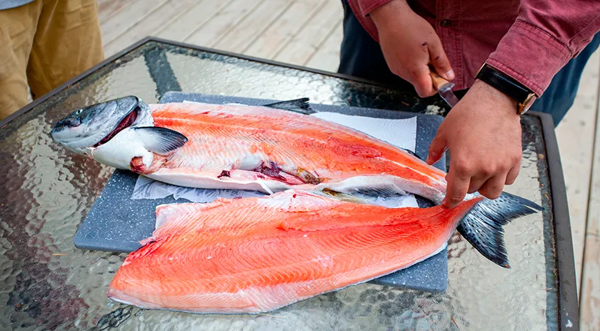 Снятие филе с кожи: сделайте надрезы вдоль хребта, отделите филе, затем, зафиксировав кожу у хвоста, под углом ведите нож от хвоста к голове, снимая мясо с кожи