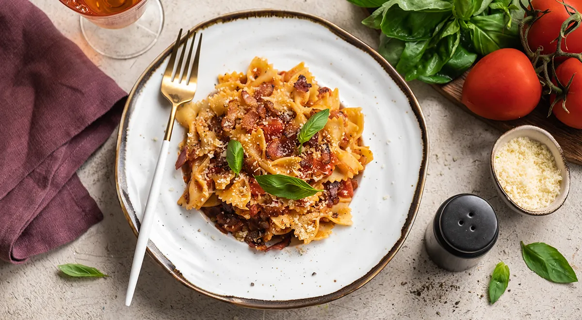 Макароны с беконом, сыром и помидорами на сковороде