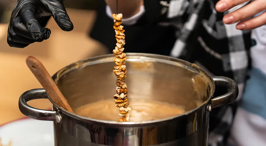 Обмакните ореховую нить в загустевший виноградный сироп, дайте стечь излишкам и сушите чурчхелу до готовности