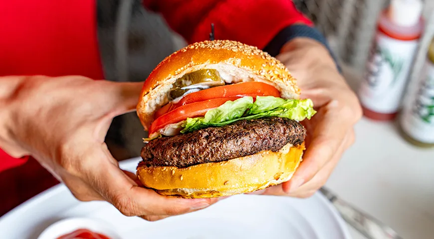 Признаки свежести гамбургера — теплая, мягкая булочка, умеренная влажность начинки, отсутствие сухих или заветренных участков любого ингредиента