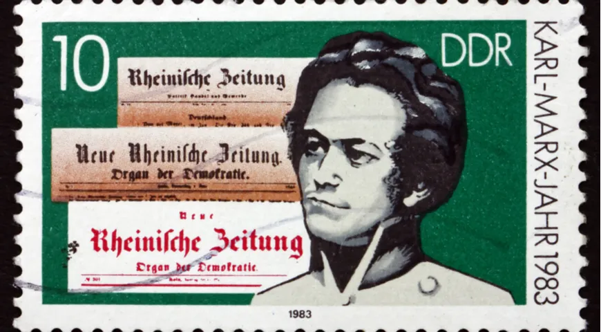 Почтовая немецкая марка 1983 г с портретом молодого Карла Маркса и заголовками газет 30-х годов XIX в.