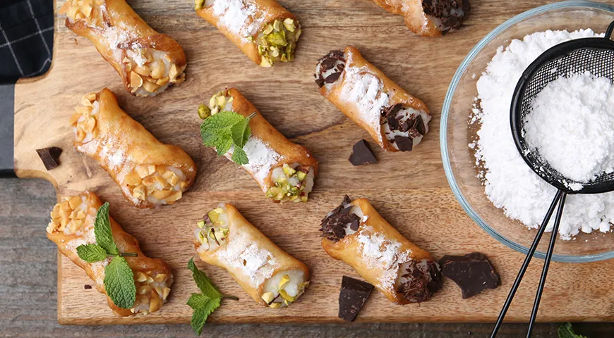 Начинку, которая выглядывает из трубочек, можно украсить рублеными орехами, шоколадом, цукатами или посыпать сахарной пудрой