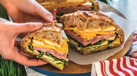 Сэндвич в хлебе с овощами, сыром и ветчиной