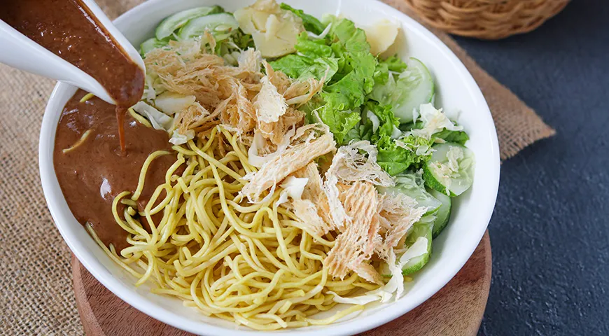 Индонезийский салат с арахисовым соусом, лапшой и сушеным кальмаром