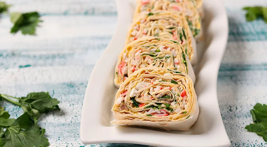 Рулет из лаваша можно приготовить, используя недорогие ингредиенты (например, крабовые палочки)