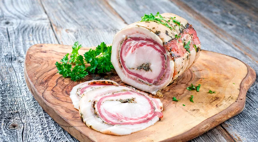 Панчетта arrotolata формируется в плотный рулет с характерным мраморным срезом и плотной текстурой