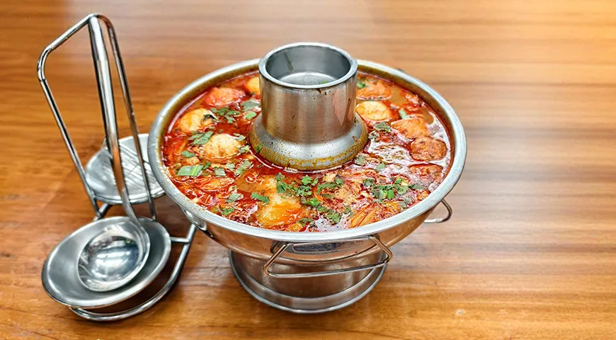 В домашних и ресторанных условиях тайцы используют для том яма специальную посуду — металлическую кастрюльку с центральной трубкой для подогрева (чом-кай)