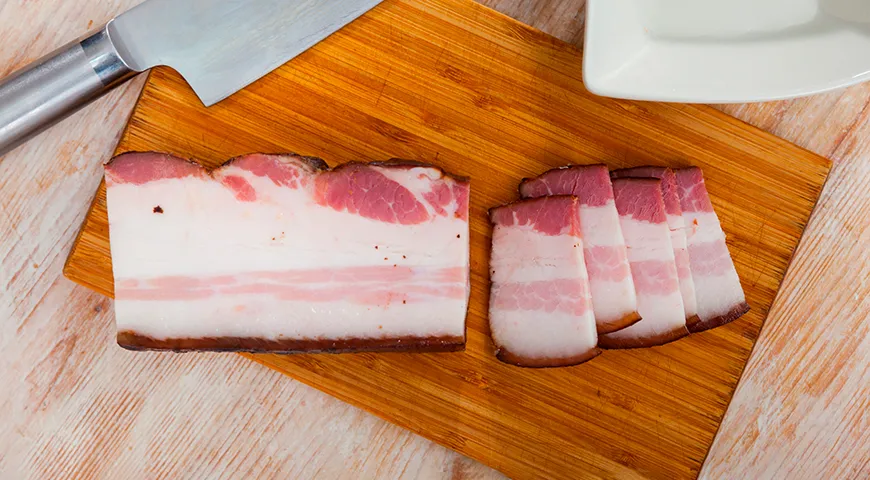 Копченое сало имеет светлый янтарный оттенок и плотную, упругую корку с выраженным дымным ароматом