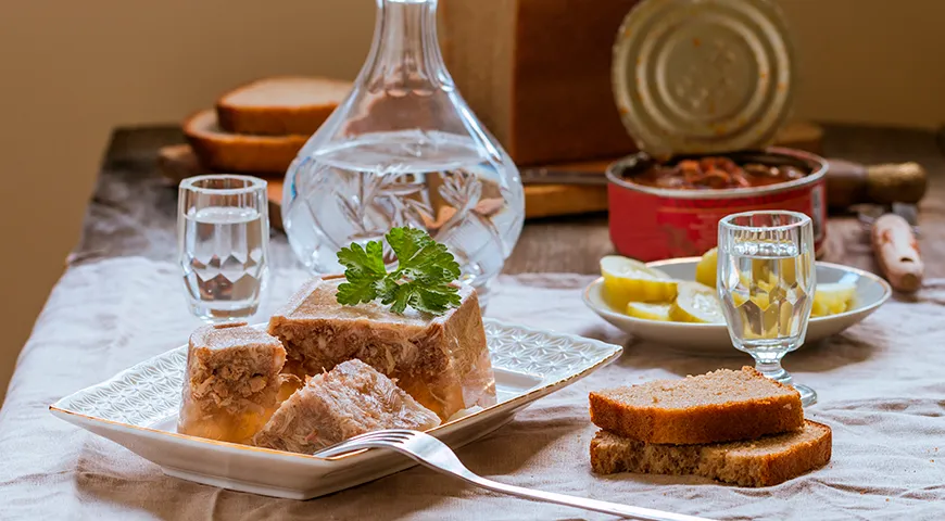 Классический холодец раскрывается в компании соленых огурцов, бородинского хлеба и водки