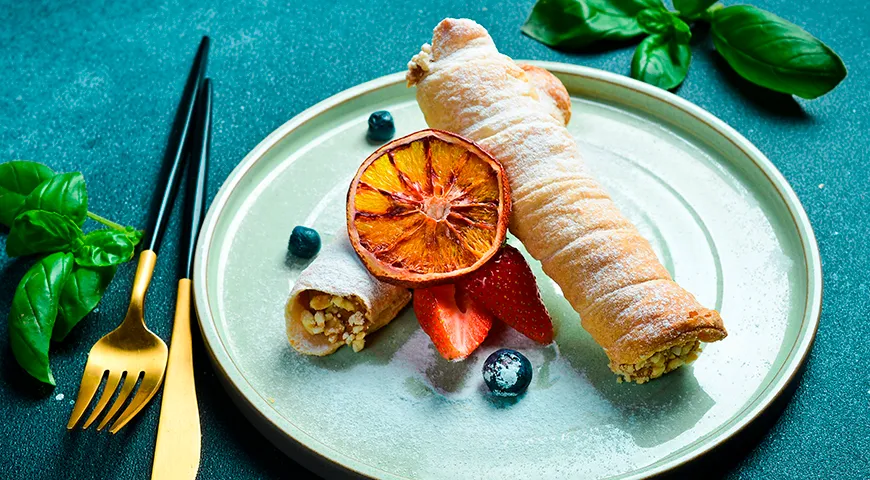 Трубочки со сгущенкой можно подать в ореховой посыпке с ягодами и сахарной пудрой