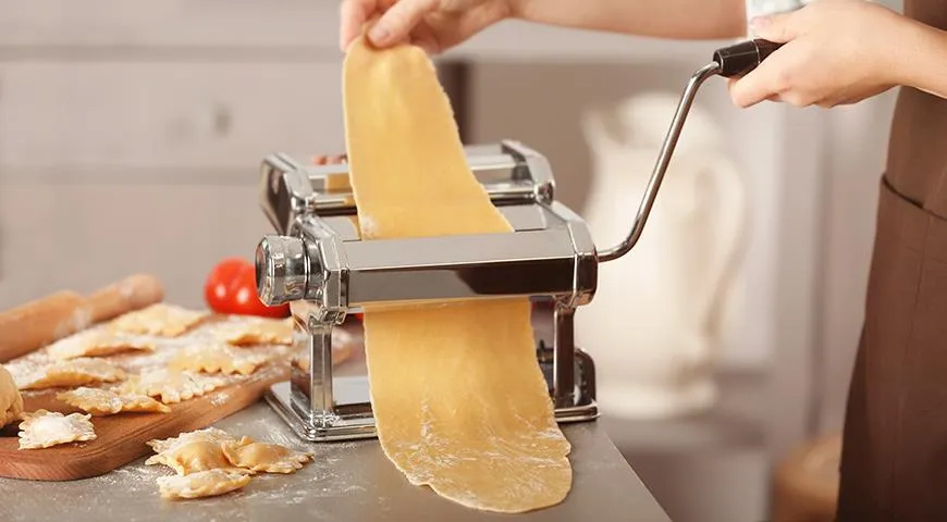 В идеале тесто для равиоли лучше всего раскатывать специальной машинкой, в ее отсутствие обычной скалкой