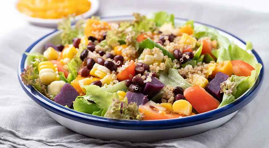 Здоровый овощной салат с фриллисом, семенами киноа, бобами азуки, кукурузой, помидорами, тыквой и фиолетовым сладким картофелем