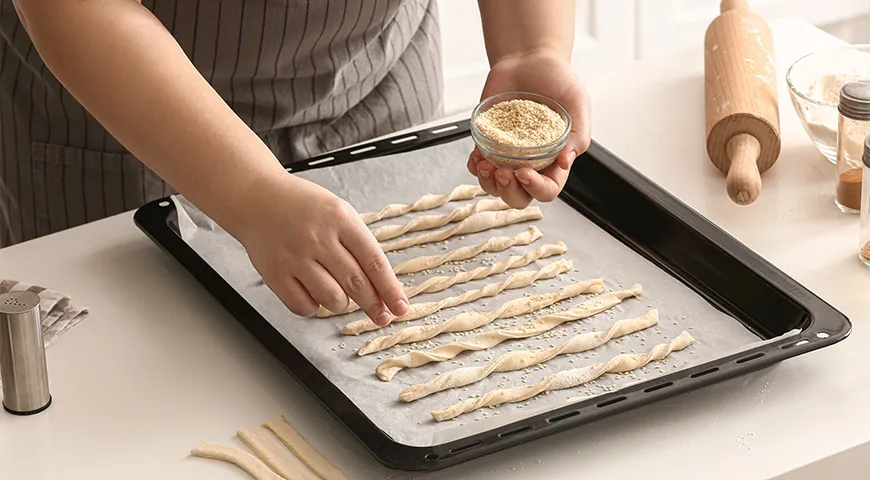 Гриссини перед выпечкой посыпают кунжутом