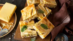 Пирог из слоеного теста с сыром, луком и курицей