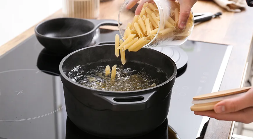 Пасту опускают в воду, которая уже активно бурлит: при резком контакте с кипятком поверхность макарон быстрее схватывается, и они будут меньше прилипать друг к другу