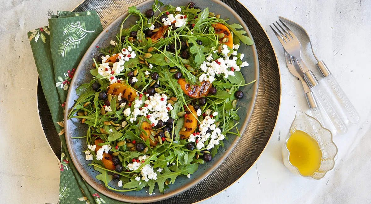 Салат с консервированными персиками, зерненым творогом, руколой и черникой