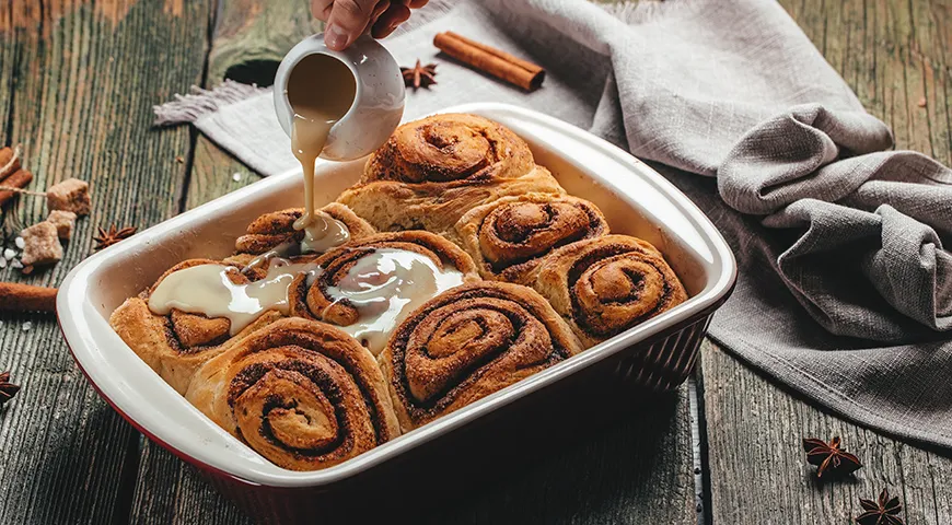 Американские синнабоны — это нежнейшее сдобное тесто, много коричной начинки и, конечно, толстый слой белой сырной глазури