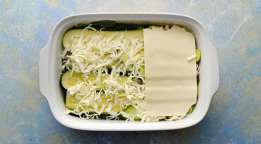 Выложите в форму листы лазаньи, чередуя их со слоями овощей и сыра в любом порядке